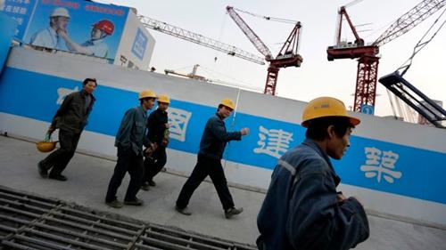Công nhân Trung Quốc bên ngoài một công trình ở Bắc Kinh. Ảnh: Reuters.