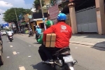 Thanh niên áo xanh GrabBike đèo bạn áo đỏ Go Việt, đội mũ Uber là hình ảnh 'ấm áp' nhất MXH hôm nay