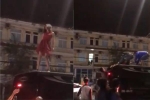 Clip sốc: Cô gái mặc váy đỏ trèo lên nóc ô tô 'nhảy múa', lăn lộn mặc người dân cố khuyên can