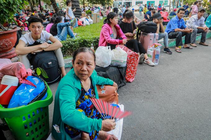 "Tôi đi một mình ra ngoài Huế ăn Tết. Tàu dự kiến chạy lúc 15h20 mà chờ hơn 3 tiếng rồi chưa thấy khởi hành", bà Đặng Thị Ái (63 tuổi) nói, vừa cầm quạt ngồi nghỉ bên ngoài phòng chờ.