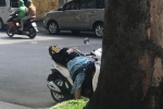 Quá mệt vì 'vật lộn' với nắng nóng gay gắt, người phụ nữ trùm kín như ninja ngả lưng trên xe SH ngủ bên lề đường