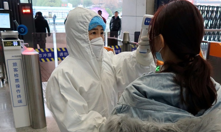 Hành khách được kiểm tra thân nhiệt tại nhà ga thành phố Hàm Ninh, tỉnh Hồ Bắc cuối tháng 1. Ảnh: Reuters.