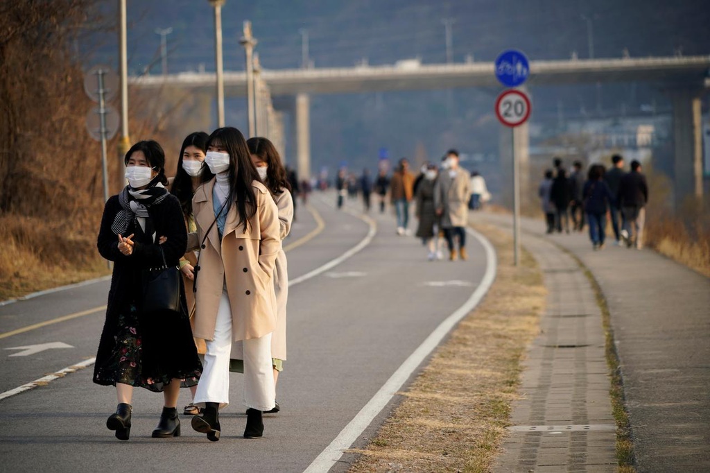 Người đeo khẩu trang đi dạo dọc công viên sông Hán ở Namyangju, Hàn Quốc, ngày 7/3. Ảnh: Reuters.