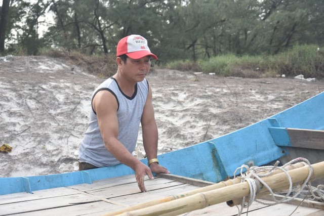 Ngư dân Nguyễn Văn Thuy kiểm tra lại những hỏng hóc của thuyền nan.