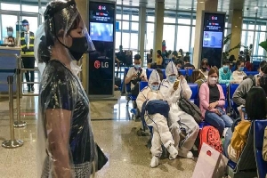 [ẢNH] Người dân mặc áo mưa, đồ bảo hộ kín mít tại sân bay Tân Sơn Nhất chờ về quê đón Tết