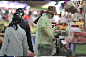 Người dân mặc áo mưa, trùm kín khi đi chợ giữa nắng 37 độ C
