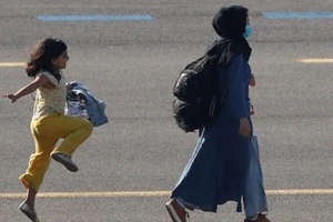 Bức ảnh em bé nhảy chân sáo sau khi rời Afghanistan gây chú ý