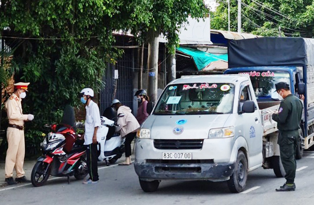 Lực lượng chức năng kiểm tra thủ tục y tế đối với người dân và tài xế tại cửa ngõ TP Sóc Trăng. Ảnh: Việt Tường.