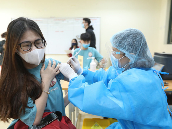 Học sinh trường THPT Phan Huy Chú, quận Đống Đa đến tiêm vaccine phòng COVID-19, sáng 23/11/2021.