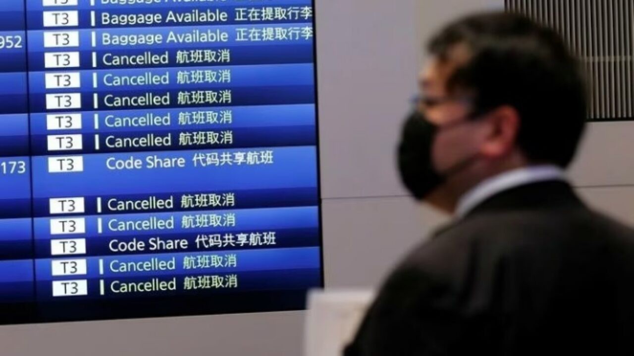 Người đàn ông đứng trước bảng điện tử hiển thị các chuyến bay bị hủy tại sân bay quốc tế Haneda, Tokyo, Nhật Bản, hôm 29/11. Ảnh: Reuters.