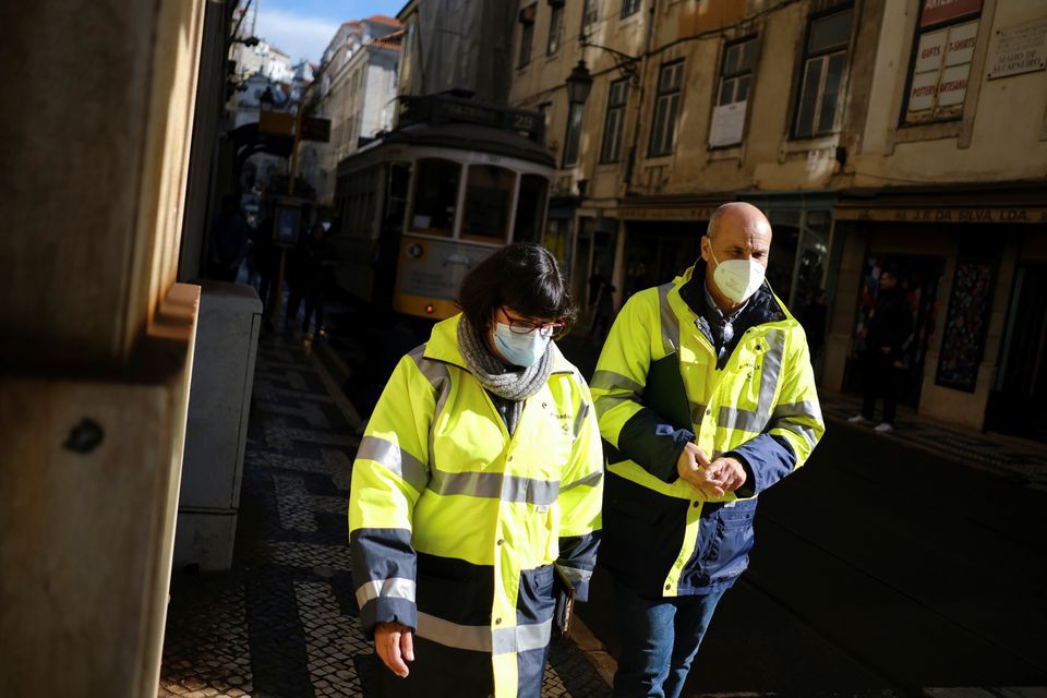 Người dân đeo khẩu trang, mặc đồ bảo hộ khi đi bộ ở trung tâm Lisbon, Bồ Đào Nha, ngày 25/11. Ảnh: Pedro Nunes/Reuters.