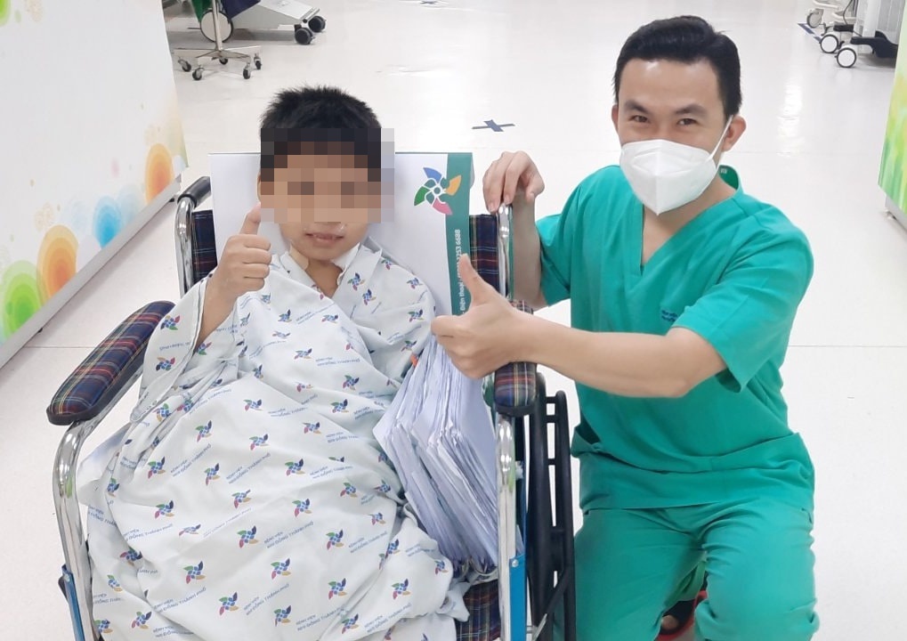 Bé trái 9 tuổi, bị viêm cơ tim sau 2 ngày mắc Covid-19, tươi tỉnh chụp hình cùng y bác sĩ trước khi xuất viện. Ảnh: Phương Vũ.
