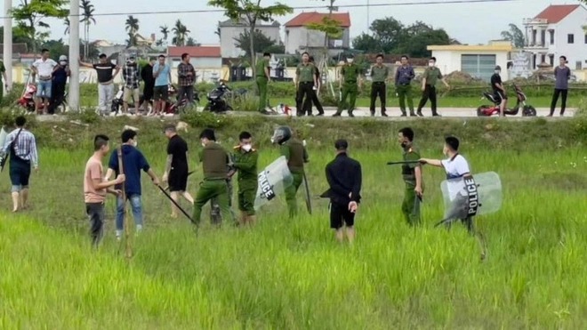 Lực lượng Công an huyện Nga Sơn khống chế kẻ cầm dao "cố thủ" dưới ruộng lúa. Ảnh: Người dân cung cấp.