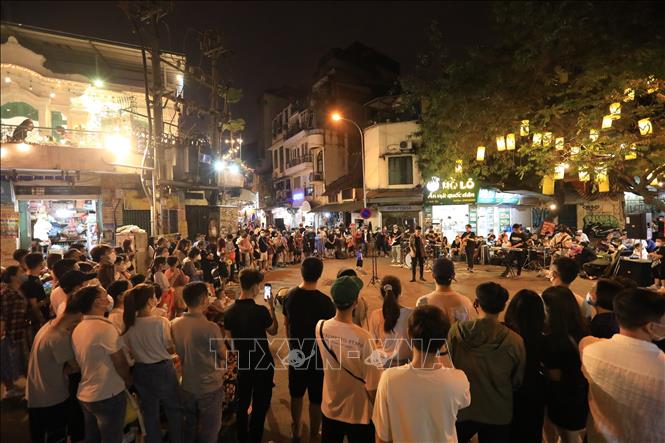 Biểu diễn văn nghệ tại ngã tư phố Đinh Liệt và Gia Ngư thu hút đông đảo người dân và khách du lịch. Ảnh: TTXVN.