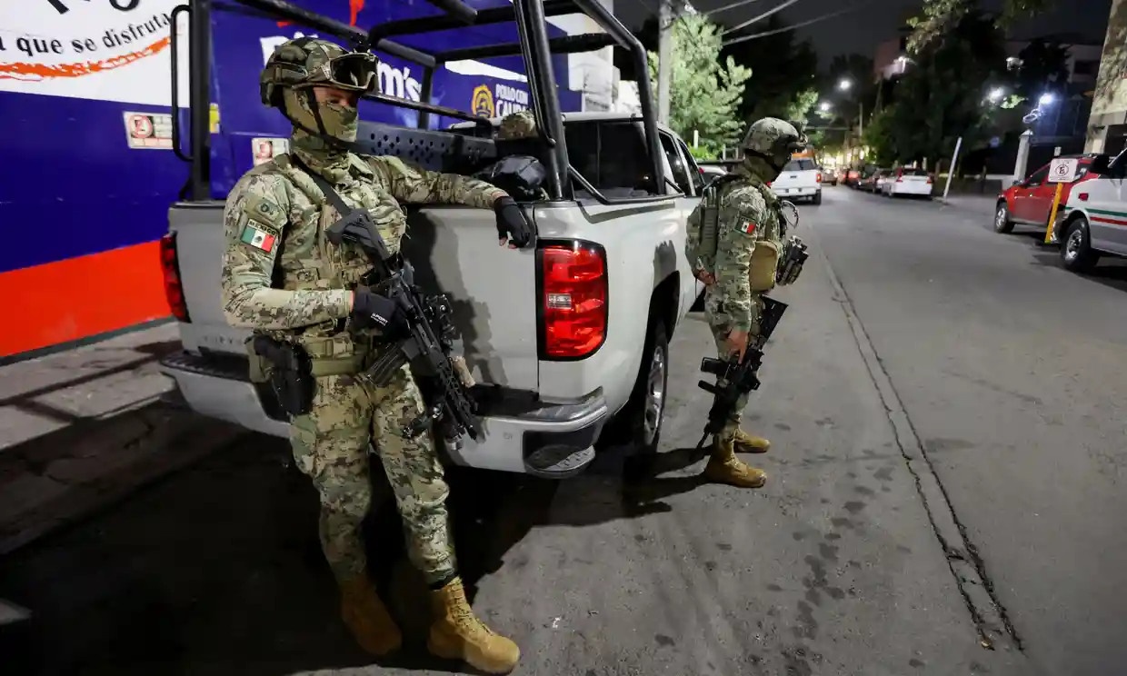 Các binh sĩ bảo vệ văn phòng chính phủ ở thành phố Mexico, nơi cựu Bộ trưởng Tư pháp Jesús Murillo bị giam giữ. Ảnh: Reuters.