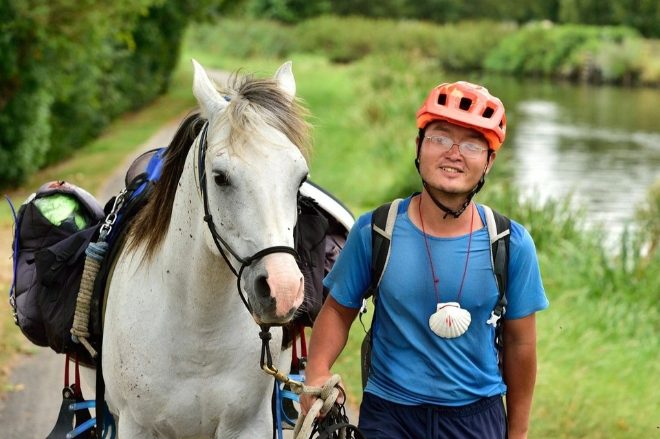 Xu Zhixian bên cạnh con ngựa của mình. Ảnh: Travellive