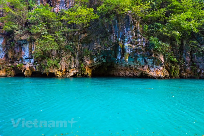 Hầu hết thời gian trong năm, nước sông Nho Quế có màu xanh ngọc lục bảo tuyệt đẹp, ánh lên giữa những chân núi đá xám lạnh, bên cạnh những mảng xanh thẫm trong không gian hùng vĩ của rừng già, đánúi và mây trời. (Ảnh: Hoài Nam/Vietnam+)