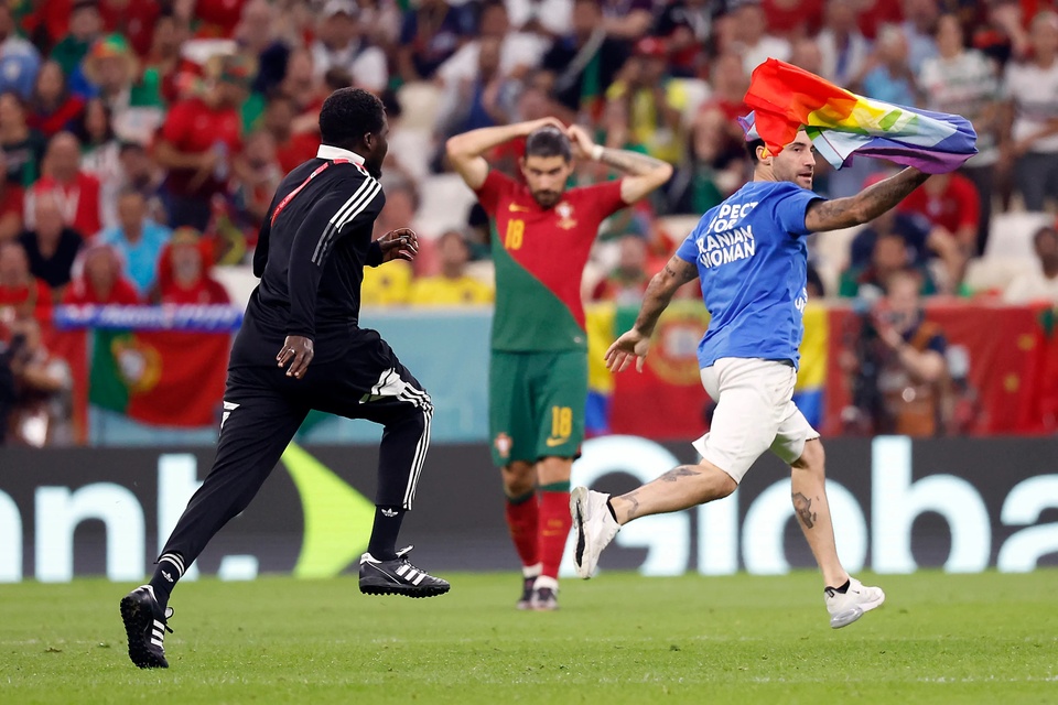 Người đàn ông cầm cờ cầu vồng chạy vào sân giữa lúc Bồ Đào Nha và Uruguay đang thi đấu. Ảnh: USA Today.