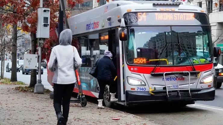 Hành khách đang lên xe buýt tại thủ đô Washington D.C. (Mỹ). Ảnh: AP