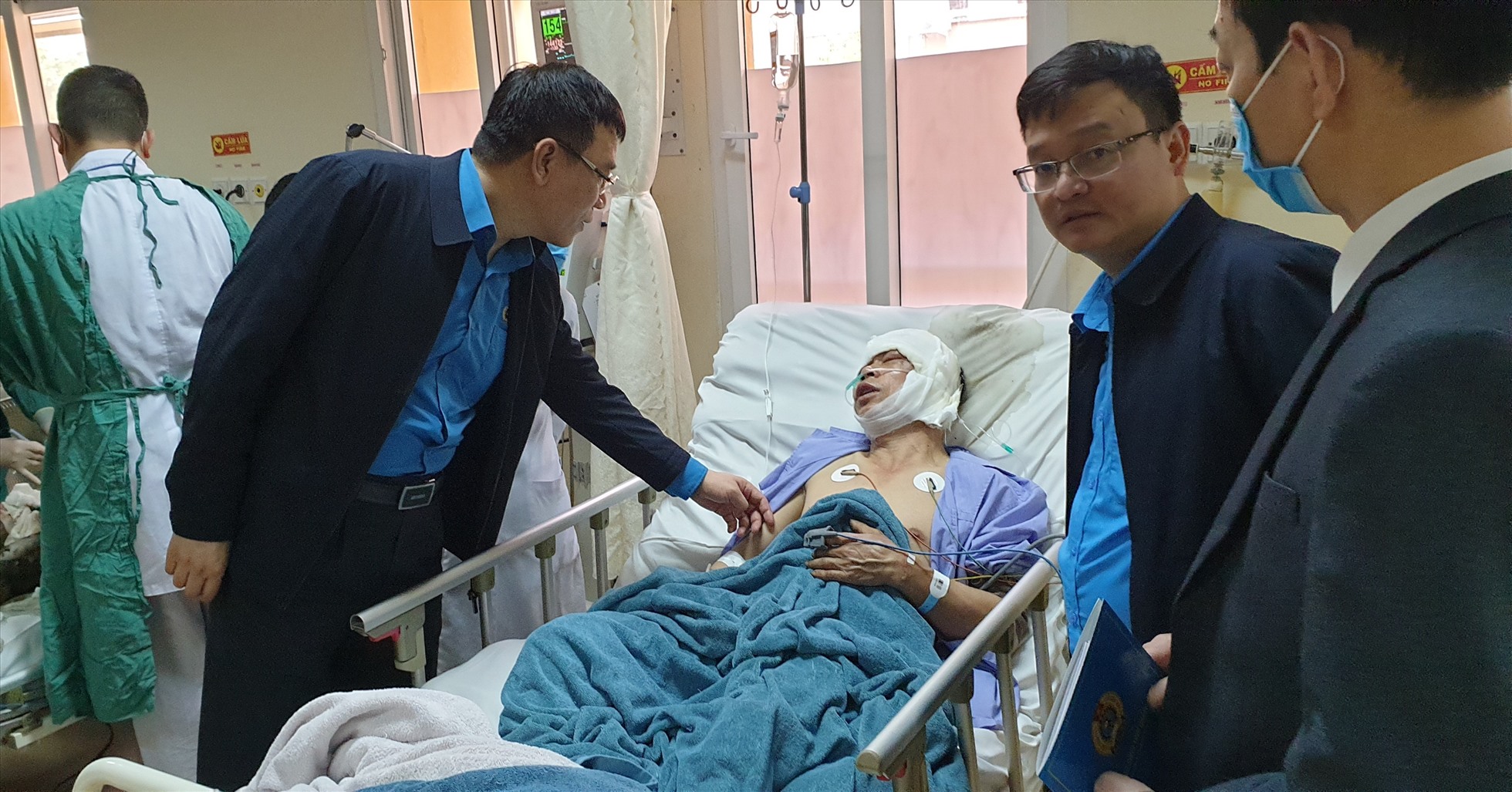 Ông Tô Xuân Thao (trái) - Chủ tịch LĐLĐ Quảng Ninh - đến thăm hỏi, trao tiền hỗ trợ cho công nhân bị tai nạn tại Bệnh viện Việt Nam - Thụy Điển Uông Bí, tỉnh Quảng Ninh. Ảnh: Nguyễn Hùng