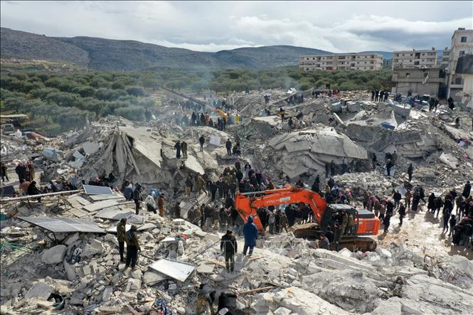 Lực lượng cứu hộ và tình nguyện viên tìm kiếm các nạn nhân và người sống sót mắc kẹt trong đống đổ nát sau động đất mạnh ở làng Besnia, gần thị trấn Harim, tỉnh Idlib (Syria), giáp giới Thổ Nhĩ Kỳ. Ảnh: AFP/TTXVN