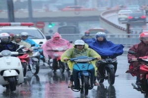 Dừng xe máy để mặc áo mưa có vi phạm pháp luật?