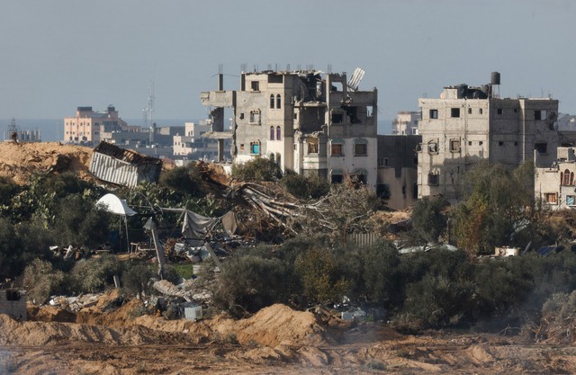 Các tòa nhà bị phá hủy ở miền Trung Dải Gaza hôm 13-1 Ảnh: REUTERS