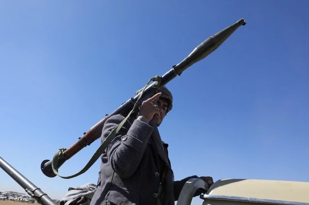 Một người ủng hộ Houthi mang theo vũ khí biểu tình phản đối việc liên minh do Mỹ dẫn đầu tấn công các mục tiêu tại Yemen. Ảnh: Reuters