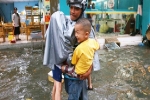 Sài Gòn sau cơn mưa 'khủng', bố mẹ bì bõm lội nước bế con đi học về